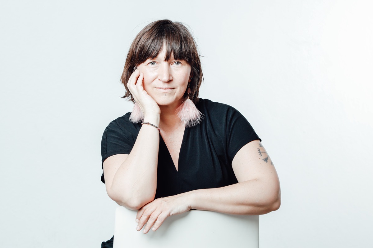 Sarah Scholz, aufgestützt, lächelt in die Kamera