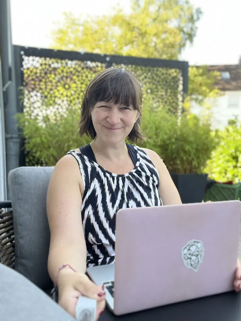 Sarah auf der Terrasse mit Laptop